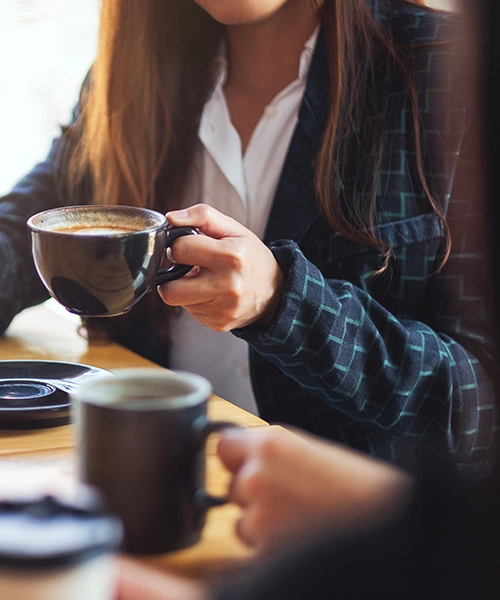 Primer plano de dos personas tomando un café