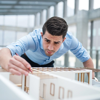 Seguros para profesionales representados por un arquitecto trabajando en su maqueta